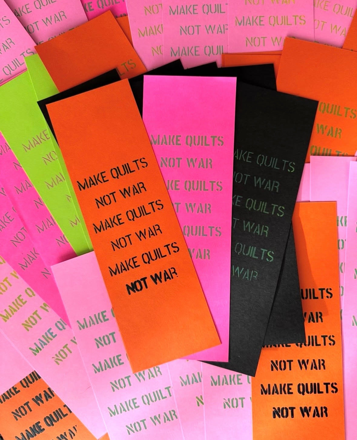 Colorful bookmarks with 'Make Quilts Not War' unique screen printed text.